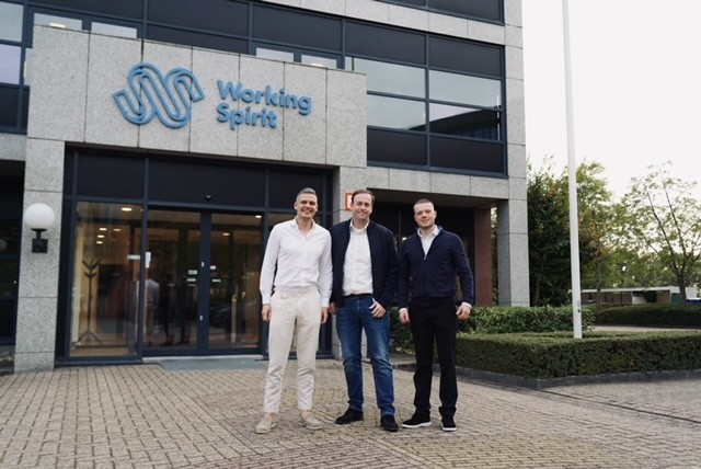 Drie mannen staan voor de ingang van het kantoorpand van Working Spirit